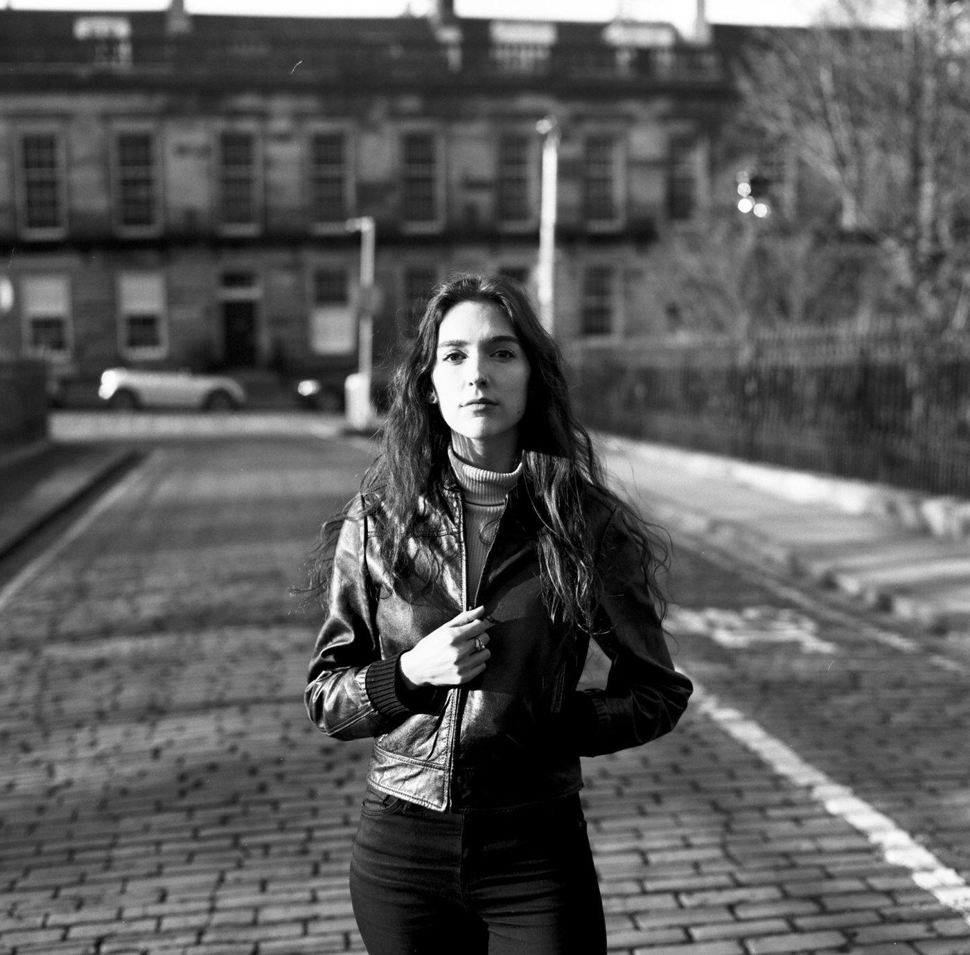 Black and white portrait in a leather jacket on a cobbled Edinburgh street